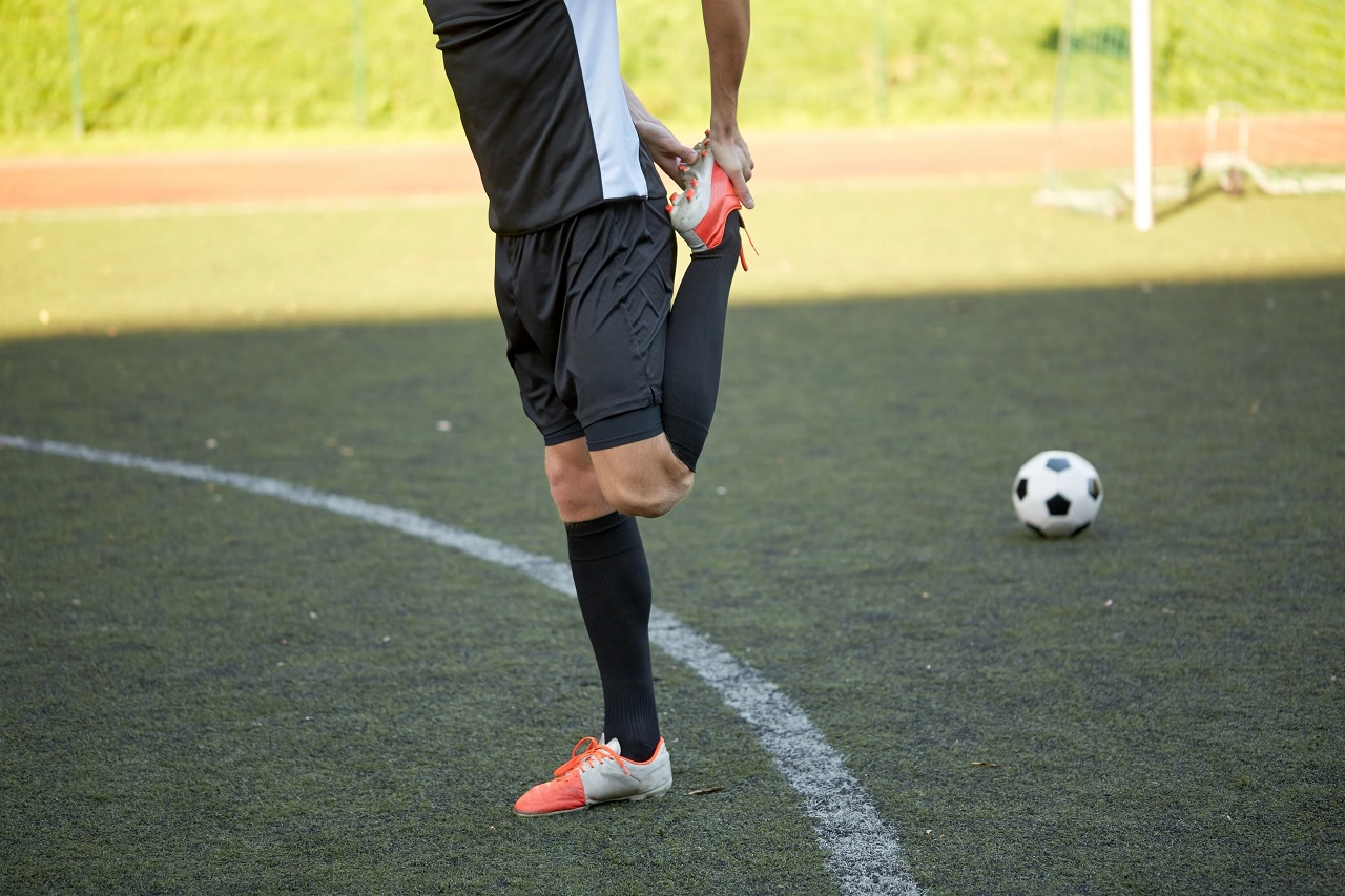 Soccer player engaged in a dynamic warm-up routine to prevent soccer injuries and prepare for optimal performance.